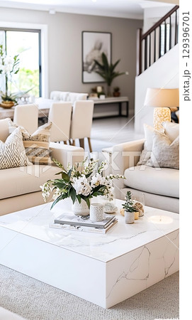 White coffee table with a vase of flowers on it White coffee table with a vase of flowers on it 129396701