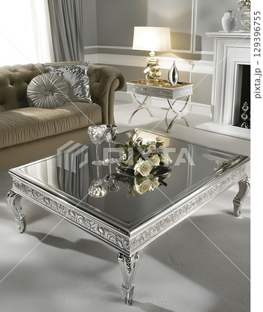 Silver coffee table with a vase of flowers on top of it 129396755