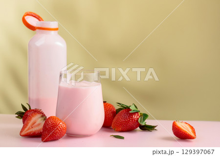 Strawberry milkshake smoothie and fresh berries on a colorful background. Strawberry milkshake smoothie and fresh berries on a colorful background. 129397067