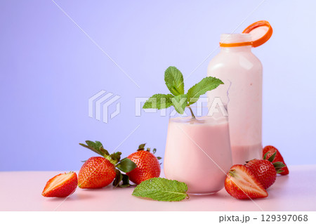 Strawberry milkshake smoothie and fresh berries on a colorful background. Strawberry milkshake smoothie and fresh berries on a colorful background. 129397068