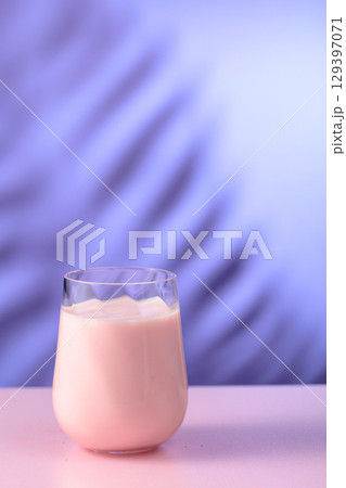 Pink smoothie, vitamin drink, or yogurt on a colorful background. 129397071