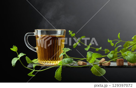 Cup of mint tea and fresh mint sprigs. 129397072