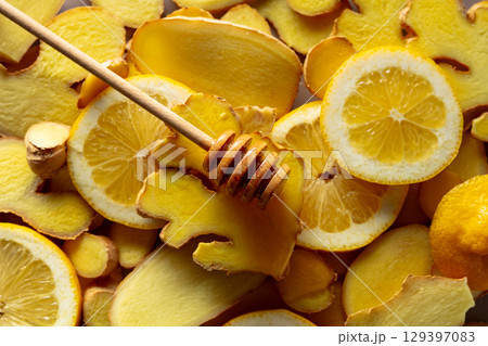Honey with fresh ginger and lemon slices. 129397083