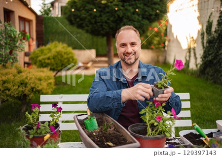 Gardening joy in a sunlit backyard oasis Gardening joy in a sunlit backyard oasis 129397143