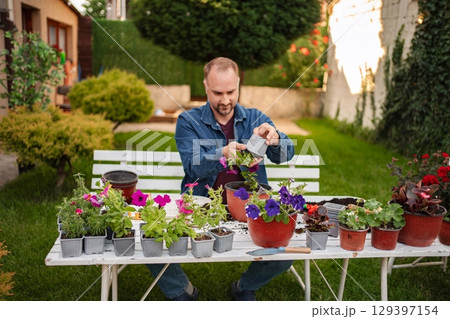 Gardening enthusiast nurturing colorful flowers outdoors Gardening enthusiast nurturing colorful flowers outdoors 129397154