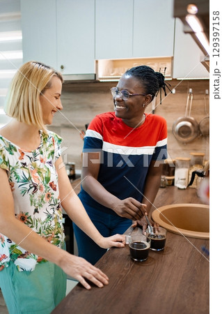 Enjoying coffee and conversation in a cozy kitchen setting Enjoying coffee and conversation in a cozy kitchen setting 129397158