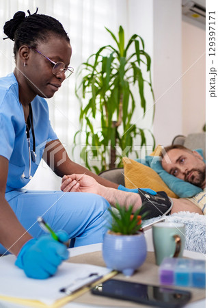 Healthcare professional tending to patient at home Healthcare professional tending to patient at home 129397171