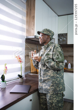 Smiling Soldier Enjoying Breakfast in Kitchen 129397205