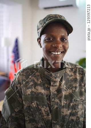 Portrait of smiling african american female soldier wearing camouflage uniform Portrait of smiling african american female soldier wearing camouflage uniform 129397213