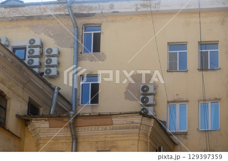Air conditioners are installed on facade of building. device for comfortable living in hot weather. 129397359
