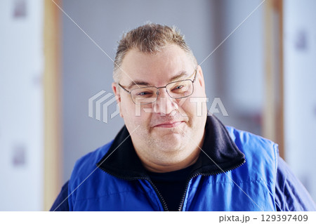 Grinning plump middle aged man of European appearance wearing glasses. Grinning plump middle aged man of European appearance wearing glasses. 129397409