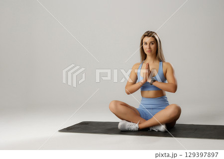 Young woman practicing yoga in comfortable studio setting while focusing on mindfulness and relaxation techniques Young woman practicing yoga in comfortable studio setting while focusing on mindfulness and relaxation techniques 129397897