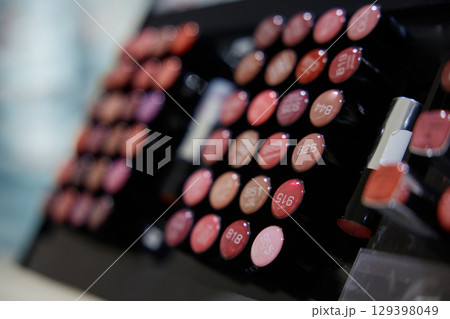 A row of lipsticks is displayed in a cosmetics store 129398049