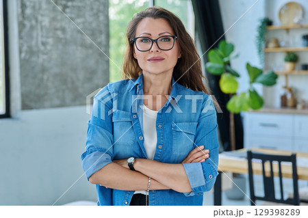 Portrait confident middle aged woman posing in home Portrait confident middle aged woman posing in home 129398289