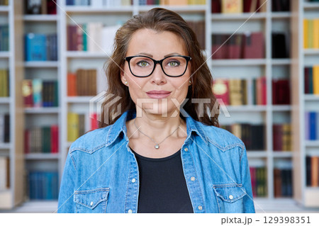 Headshot portrait smiling mature woman teacher in classroom Headshot portrait smiling mature woman teacher in classroom 129398351