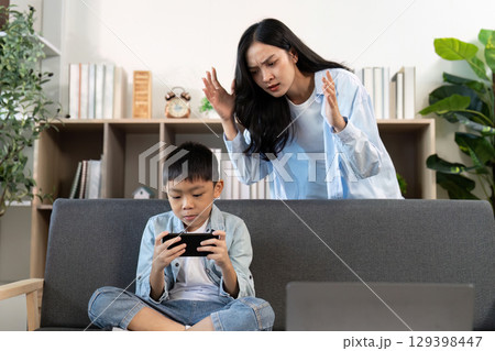 Mother scolding son for excessive gaming at home Mother scolding son for excessive gaming at home 129398447