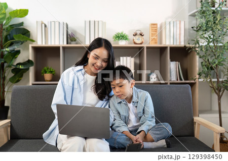 Family Time. Mother and son sharing a fun moment together while using a laptop. Family Time. Mother and son sharing a fun moment together while using a laptop. 129398450