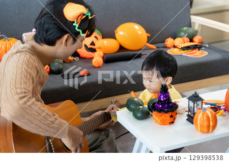 Halloween Fun. Father sharing musical moments with son surrounded by decorations. 129398538