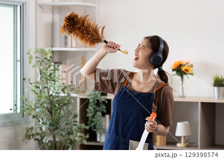 Energetic Cleaning. A woman singing while dusting her home. 129398574