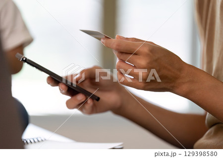 Financial planning. Adult using smartphone and credit card for online transactions. Financial planning. Adult using smartphone and credit card for online transactions. 129398580