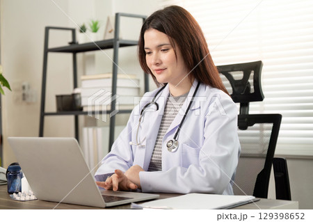 Telemedicine Consultation. A doctor engaging with patients online from a modern office. 129398652