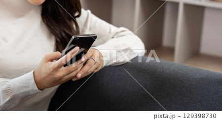 Engaged Interaction. Young woman using smartphone while relaxing at home. 129398730