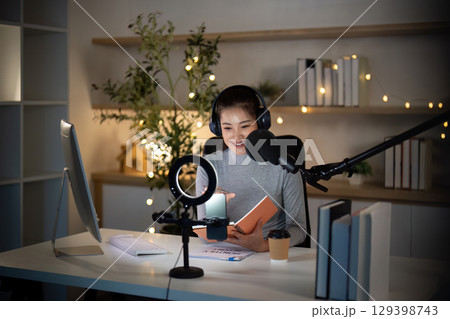 Podcast recording session with young woman in cozy studio 129398743