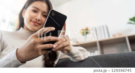 Smartphone Interaction. Young woman enjoying mobile device at home. Smartphone Interaction. Young woman enjoying mobile device at home. 129398745