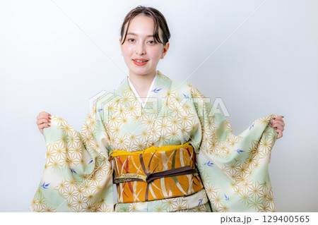 花を持つ着物姿の女性 129400565