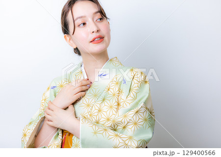 花を持つ着物姿の女性 129400566