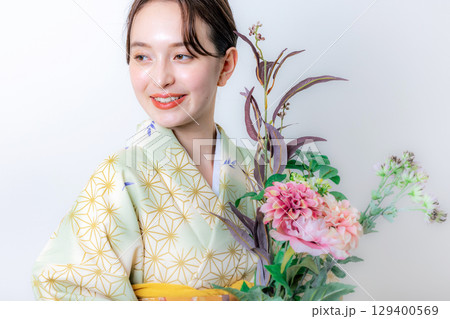 花を持つ着物姿の女性 129400569