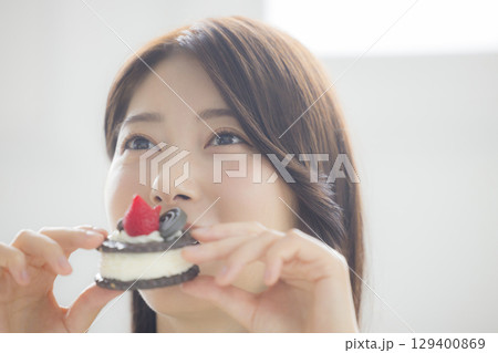 ケーキを食べる若い女性　 129400869