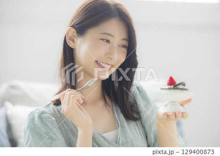 ケーキを食べる若い女性 ケーキを食べる若い女性 129400873
