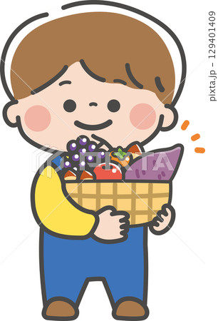 秋の味覚がいっぱい入ったかごを持つ男の子 129401409