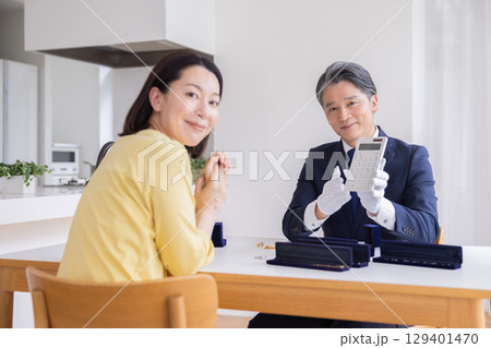 出張買取　自宅で査定をしてもらっている主婦 129401470