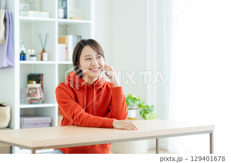 リビングで電話する若い女性 リビングで電話する若い女性 129401678