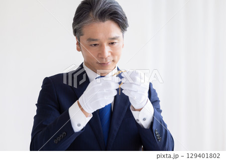 出張買取　貴金属の査定をしている男性 129401802