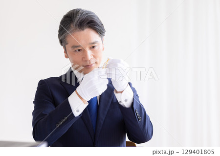 出張買取 貴金属の査定をしている男性 出張買取 貴金属の査定をしている男性 129401805