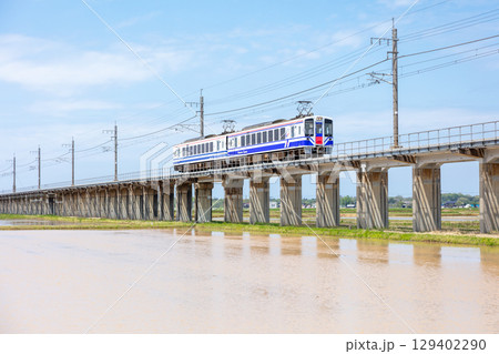 【ほくほく線】水田広がる高架を走行する普通列車 129402290