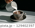 Pouring Creamy Milk into a Warm Coffee Cup with Smooth Texture and Soft Natural Light 129402397