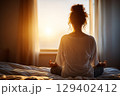 Peaceful Morning Yoga Practice by Window with Soft Sunlight in Cozy Indoor Space 129402412