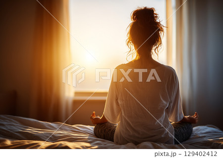 Peaceful Morning Yoga Practice by Window with Soft Sunlight in Cozy Indoor Space 129402412