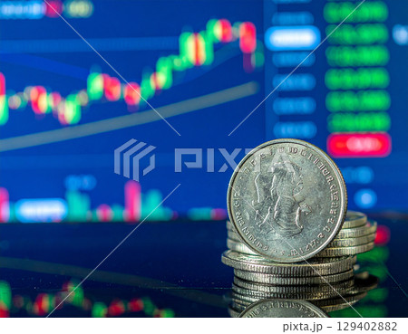 AI generated stack of physical bitcoin coins on reflective glass surface with modern cryptocurrency exchange backdrop showing digital asset price boards and trading monitors 129402882