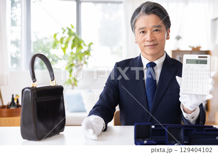 出張買取 査定 訪問先で鑑定をしている男性 出張買取 査定 訪問先で鑑定をしている男性 129404102