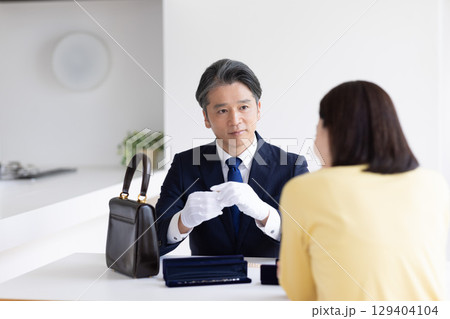 出張買取 査定 訪問先で鑑定をしている男性 出張買取 査定 訪問先で鑑定をしている男性 129404104