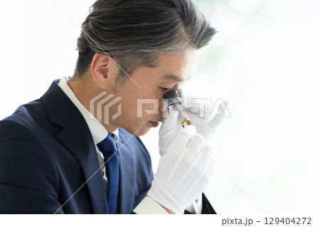 出張買取　貴金属の査定をしている男性 129404272