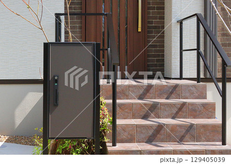 住宅の玄関に設置された宅配ボックス 129405039
