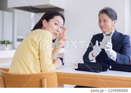 出張買取　自宅で査定をしてもらっている主婦 129406088