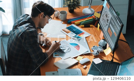 Professional designer writing and designing logo graphic at meeting. Symposium. 129406110
