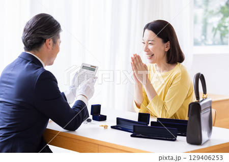 出張買取　自宅で査定をしてもらっている主婦 129406253